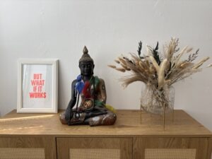 Buddha-Figur mit Trockenblumen in der Praxis von Daniela Hölzer